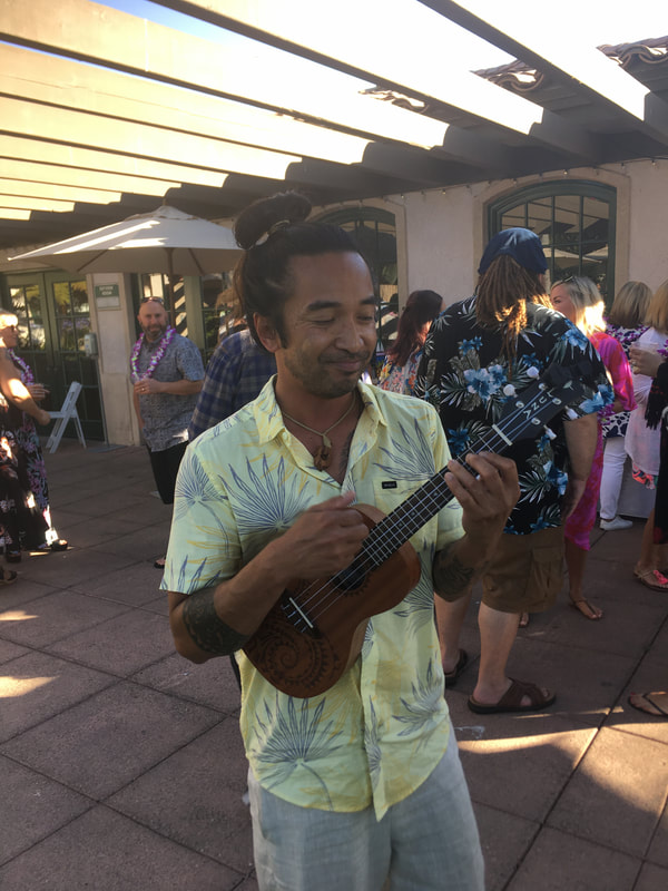 Ukulele player performing at outdoor luau party
